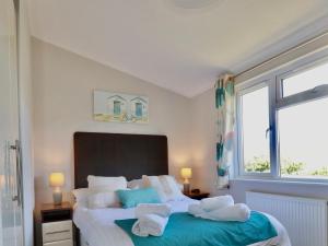 1 dormitorio con 1 cama grande y toallas. en 23 Bossiney Bay, en Tintagel