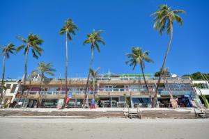 um hotel na praia com palmeiras em Diamond Water Edge Resort em Boracay