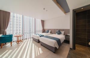 um quarto de hotel com duas camas e uma grande janela em The Time Hotel em Nha Trang