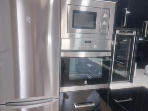 a stainless steel oven with a microwave above it at Chalet con vista a las Islas Cíes in Sanxenxo