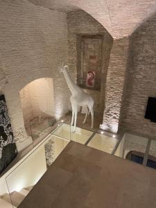 a glass table with a statue of a giraffe in a room at DesArt sweet Poeta in Perugia