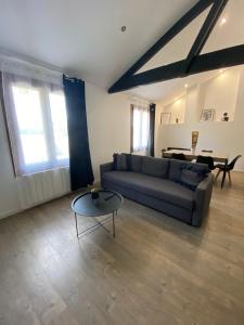 a living room with a couch and a table at Logement calme et confortable au cœur de Loupiac in Loupiac-de-Cadillac +7 photos