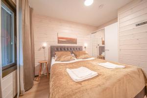 une chambre avec un grand lit avec deux serviettes dessus dans l'établissement Levillas Sointuilevi 1B66, 2 ski pass included, à Levi