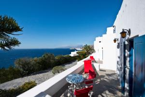 a row of tables and chairs on a balcony with the ocean at AEGEAN in Mikonos +11 photos