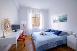 sypialnia z łóżkiem i biurkiem z komputerem w obiekcie Bel Appartement Face à La Mer Près Du Centre - Le Voilier by Halldis w Cannes