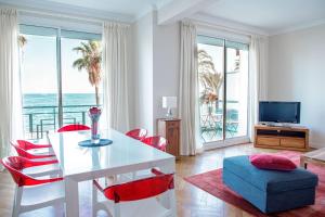 a living room with a white table and red chairs at Bel Appartement Face à La Mer Près Du Centre - Le Voilier in Cannes