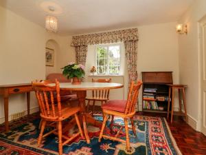 a dining room with a table and chairs and a window at Vine Cottage in Minehead