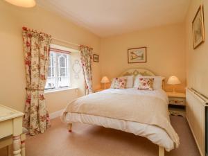 a bedroom with a bed and a window at Vine Cottage in Minehead
