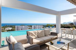a patio with a couch and chairs and a pool at Luxury Villa Hera with Private Pool in Afantou