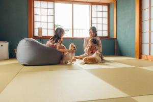 伊東市にあるchillout house 大室山の三匹の犬と床に座っている女の子