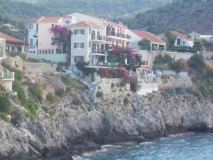 a group of houses on a cliff next to the water at GARY APARTMENTS in Asos