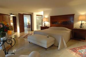 a bedroom with a bed and a chair and a table at Marti Resort Deluxe Hotel in Marmaris