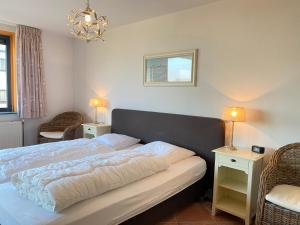 a bedroom with a bed with two tables and two chairs at Callantsoger Staete A109 in Callantsoog