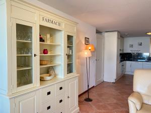 a kitchen with white cabinets and a lamp in a room at Callantsoger Staete A109 in Callantsoog +4 photos
