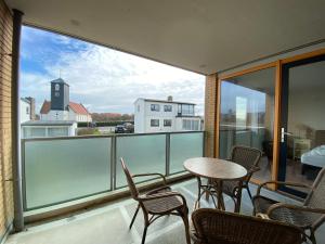 a balcony with chairs and a table with a view at Callantsoger Staete A109 in Callantsoog