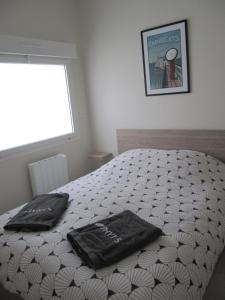- une chambre avec un lit doté de 2 oreillers noirs dans l'établissement Venez vous ressourcer sur les falaises de Meschers, à Meschers-sur-Gironde