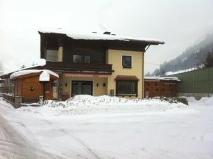 dom ze śniegiem na ziemi przed nim w obiekcie Sixtl, Landhaus w mieście Bad Hofgastein