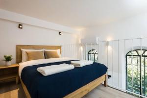 a bedroom with a large bed with two towels on it at Musrara #2 in Jerusalem