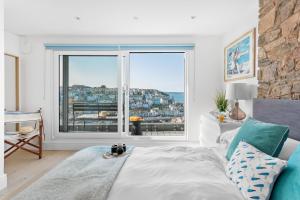 a bedroom with a bed and a large window at The Captain's Cottage, Brixham in Brixham