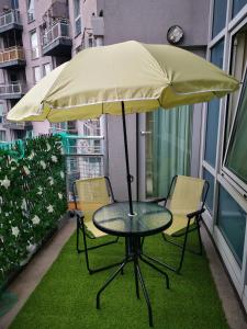 a table and chairs under an umbrella on a balcony at Town Centre Penthouse in Basingstoke