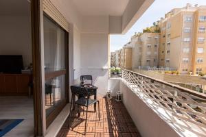 uma varanda com duas cadeiras e uma mesa num edifício em Metro Lapa House with sunny balcony and A/C no Porto