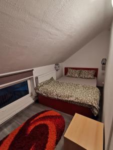Dormitorio pequeño con cama y alfombra en Căsuța de munte, en Mărişel