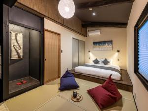Schlafzimmer mit einem Bett und roten und blauen Kissen in der Unterkunft Sansuikyo Machiya House in Kanazawa