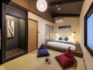 a bedroom with a bed and red and blue pillows at Sansuikyo Machiya House in Kanazawa