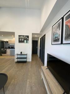 a large living room with white walls and wooden floors at Appartement confortable et paisible in Loupiac-de-Cadillac