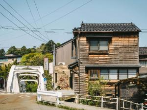 ein Gebäude an der Seite einer Straße mit einer Brücke in der Unterkunft Sansuikyo Machiya House in Kanazawa