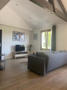 a living room with a couch and a flat screen tv at Appartement confortable et paisible in Loupiac-de-Cadillac