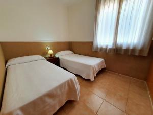 Postel nebo postele na pokoji v ubytování Apartaments Las Dunas