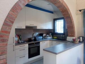 an archway in a kitchen with white cabinets at Casa Carmen in Begur