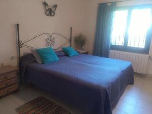 a bedroom with a blue bed with a butterfly on the wall at Casa Carmen in Begur