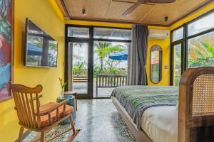 a bedroom with yellow walls and a bed and a chair at May Villa 6BR Beachfront An Bang Beach Hoi An by Beachside Boutique Homes in An Bàn (2)