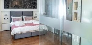 1 dormitorio con 1 cama y pared de cristal en 9 Nine - Luxury Apartments & Suites en Belgrado