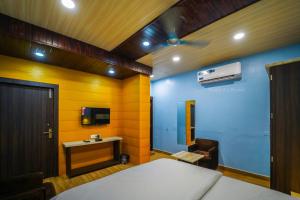 um quarto com uma cama, uma secretária e um lavatório. em Manas AC Rooms em Ratlām