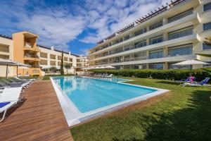 a swimming pool in front of a building at Laguna - Vilamoura in Vilamoura
