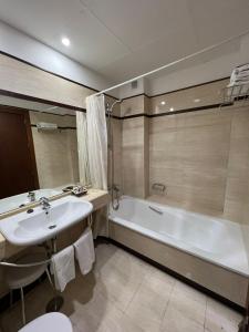 a bathroom with a sink and a bath tub at Alojamientos Cervantes in Linares