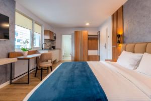 クルジュ・ナポカにあるSarmiHouseの大きなベッドとキッチンが備わるホテルルームです。
