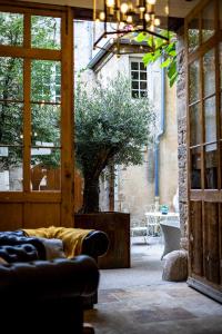 uma sala de estar com um sofá e uma árvore em Les Remparts Hôtels et Demeures Historiques em Beaune
