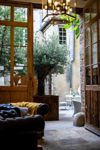 sala de estar con sofá y árbol en Les Remparts Hôtels et Demeures Historiques en Beaune