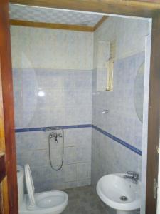 a bathroom with a shower and a toilet and a sink at R&R Gardens Hotel in Mbale