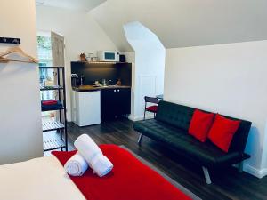 The Loft @ Denver في East Maitland: غرفة معيشة مع أريكة خضراء ووسائد حمراء