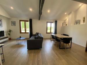 a living room with a couch and a table at Logement calme et confortable au cœur de Loupiac in Loupiac-de-Cadillac