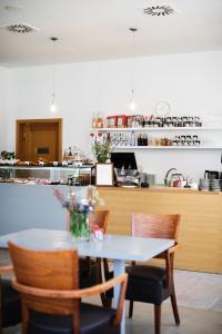 a dining room with a table and chairs and a counter at Hotel Farma in Pelhřimov