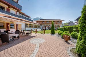 un patio con mesas y sillas y un edificio en Hotel Zum Gourmet, en Seefeld in Tirol