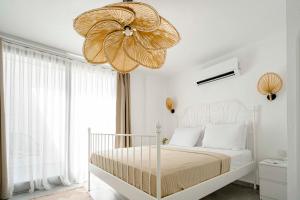 a bedroom with a bed with a large flower chandelier at Voger Alaçatı Köyiçi in Alacati +136 photos