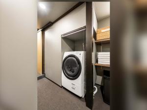 a room with a washing machine in a closet at Sansuikyo Machiya House in Kanazawa