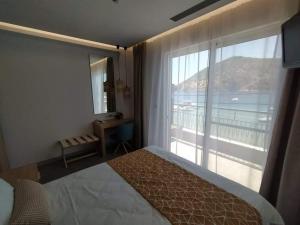una camera d'albergo con un letto e una grande finestra di Minoa Hotel a Tolo
